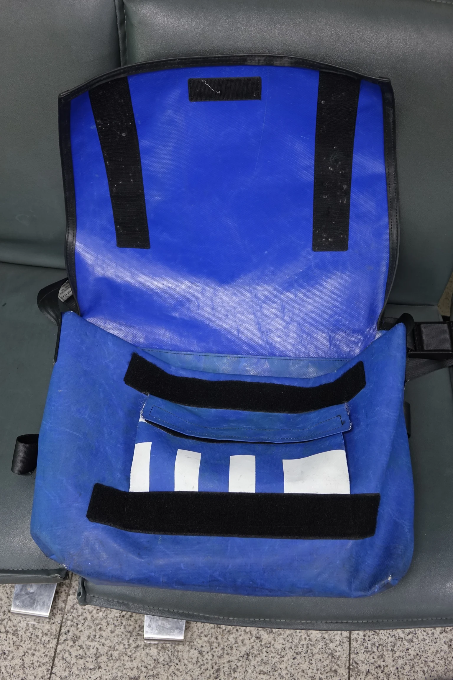 青いFREITAGバッグを開き、幌の表面、縁、黒い面ファスナーが見える