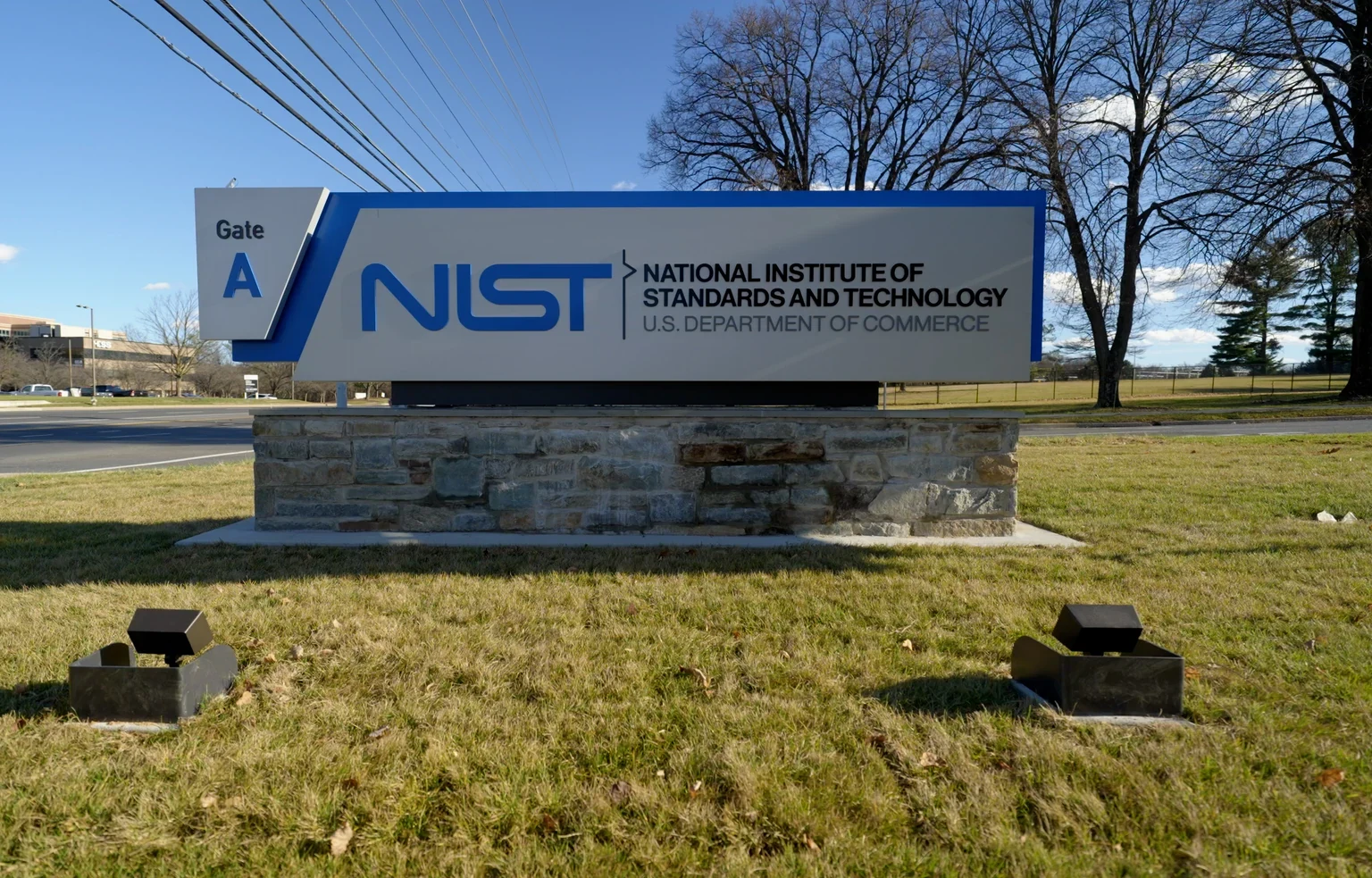 前景にNISTの表示板があり、木々の奥に研究施設が見えるゲイザースバーグキャンパス