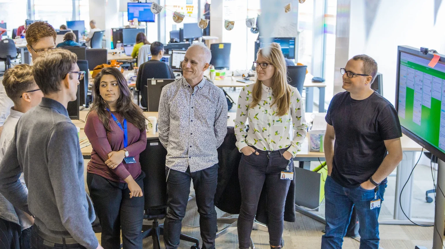 オフィスで大きなボードを囲むGOV.UKのcontent transformation team