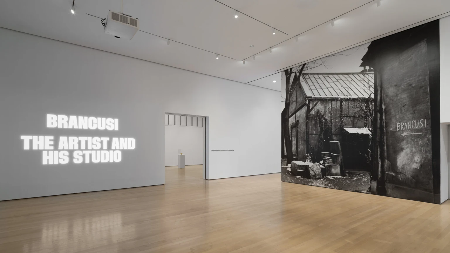 白い壁に展覧会名が投影され、右側にブランクーシのパリのスタジオ写真が大きく掲示されたMoMA展入口