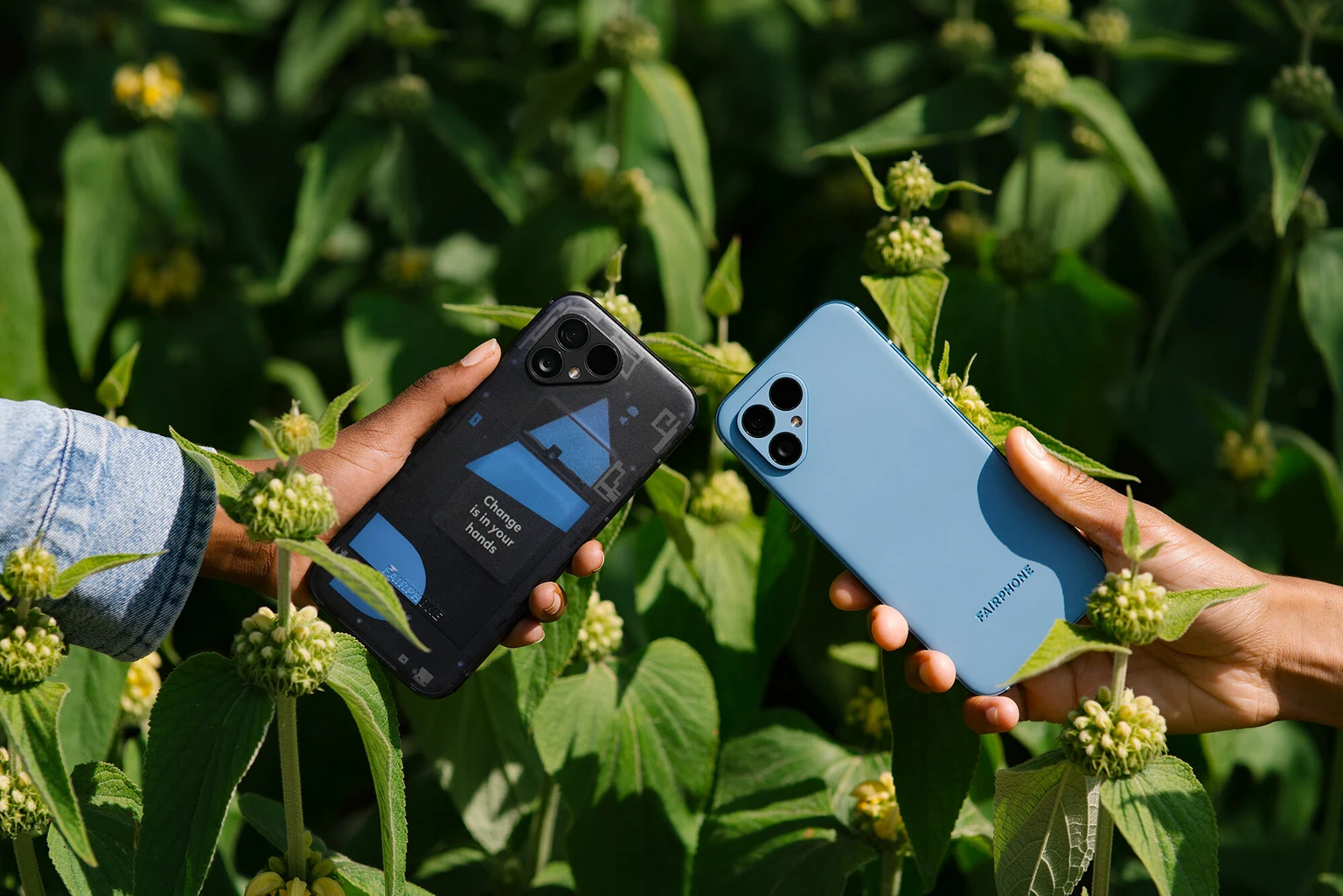 透明な背面のFairphone 5と青い背面のFairphone 5をそれぞれ手で持つ様子